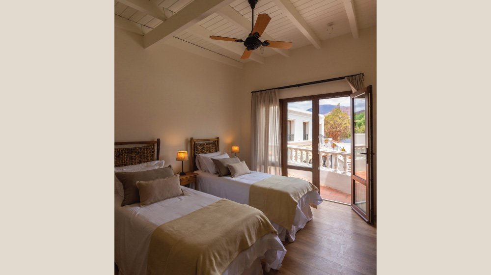 Camas twin y vista a los cerros  en las habitaciones estándar en planta alta con aire acondicionado del Hotel El Candil en Tilcara, Jujuy.