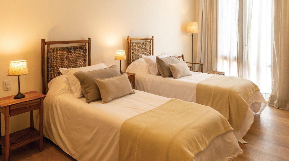 Respaldares de cama de cuero trenzado de las habitaciones estándar en planta baja con aire acondicionado del Hotel El Candil en Tilcara, Jujuy.