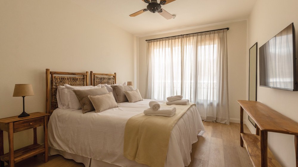 Cama doble y aire acondicionado habitación suite con terraza del Hotel El Candil en Tilcara, Jujuy. 