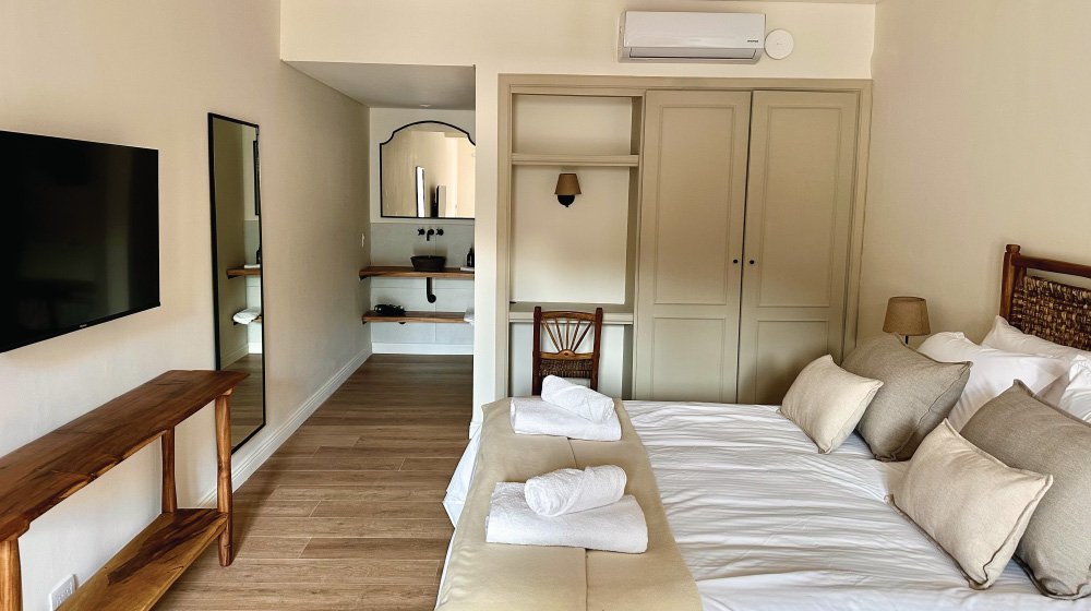 Cama doble, ropero y antebaño de la habitación triple estándar en planta baja con aire acondicionado del Hotel El Candil en Tilcara, Jujuy