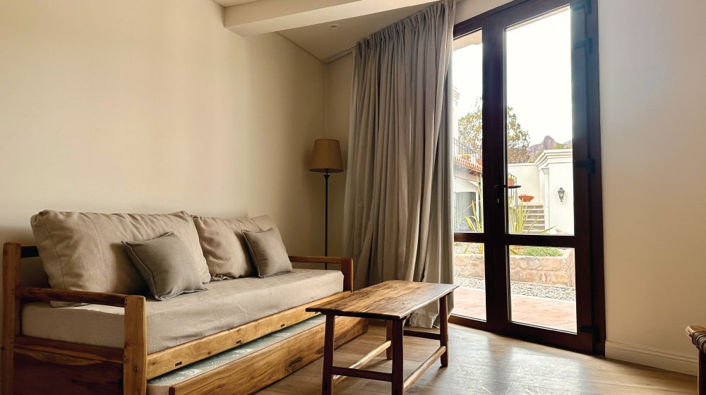 Living-estar de la habitación triple estándar en planta baja con aire acondicionado del Hotel El Candil en Tilcara, Jujuy